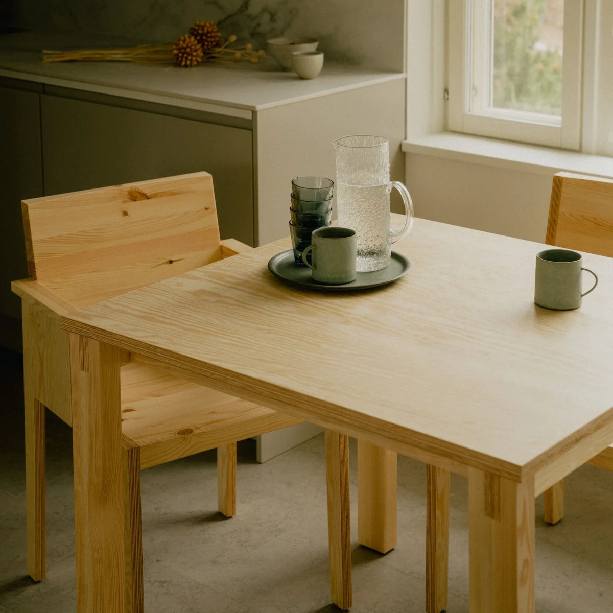 Silla de madera clara con reposabrazos para comedores elegantes