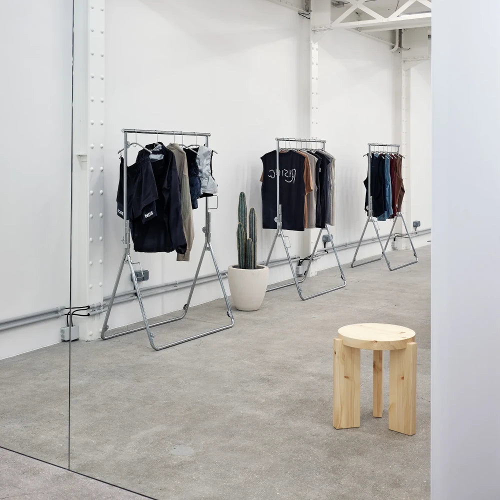 Taburete de diseño minimalista en madera clara para espacios comerciales.