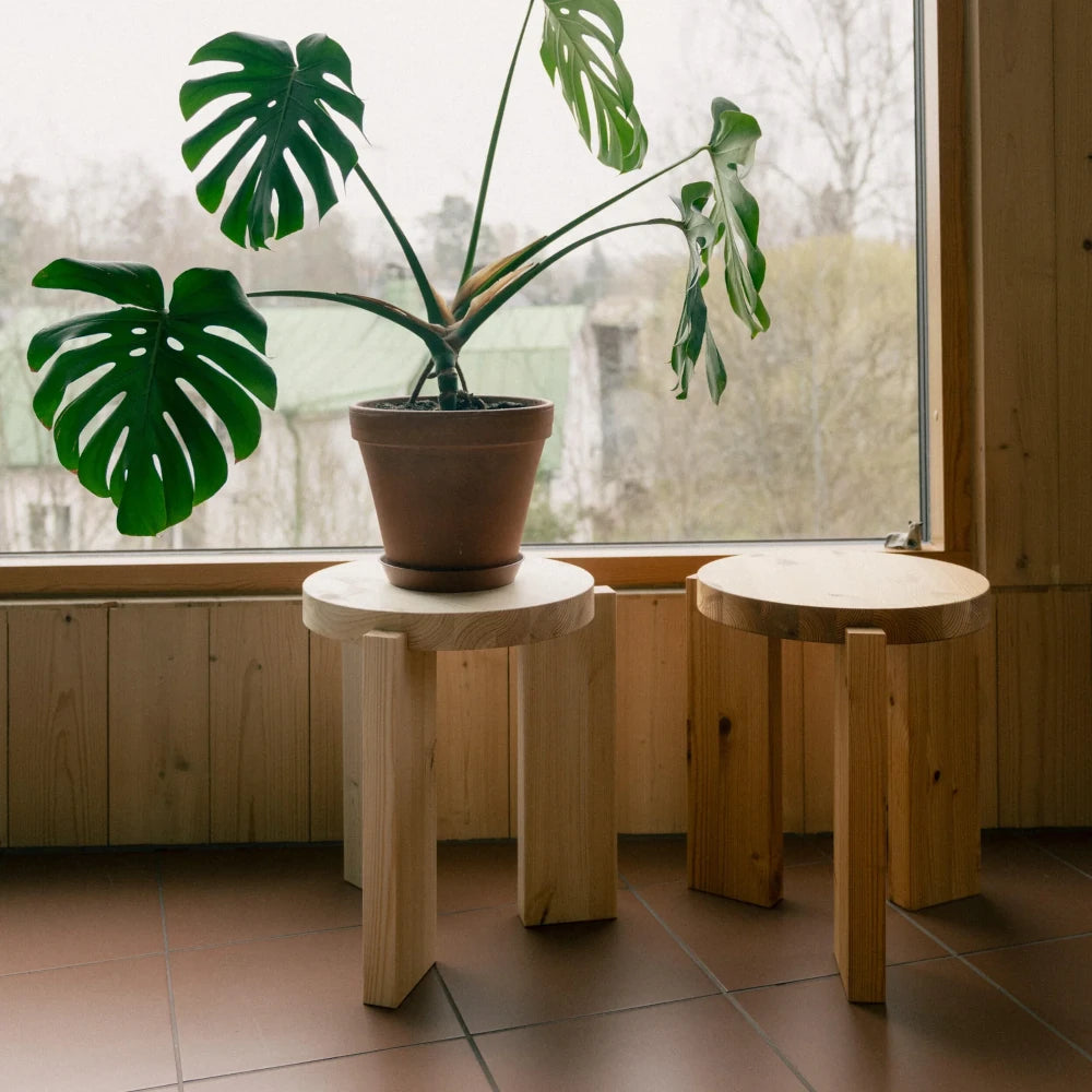 Taburete bajo de madera natural para salones y dormitorios contemporáneos.